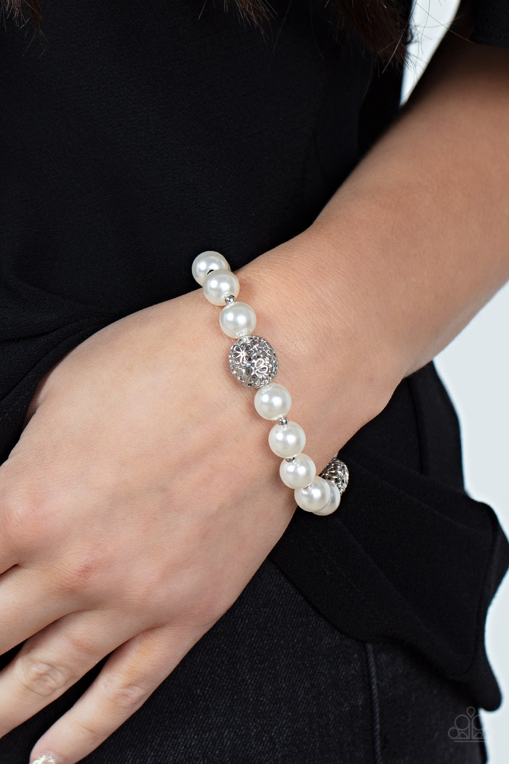 Airy silver beads, featuring a floral filigree design, add a touch of whimsy to a strand of luminous white pearl-like beads