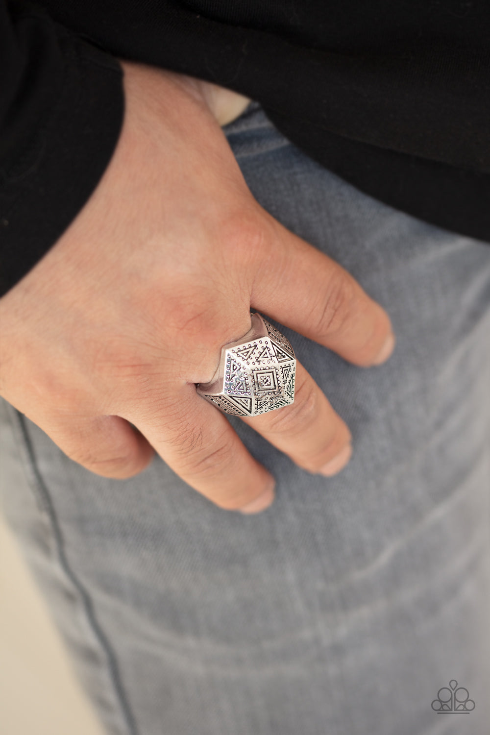 Stamped in tribal inspired triangular textures, a faceted silver frame coalesces into a bold geometric centerpiece atop the finger.