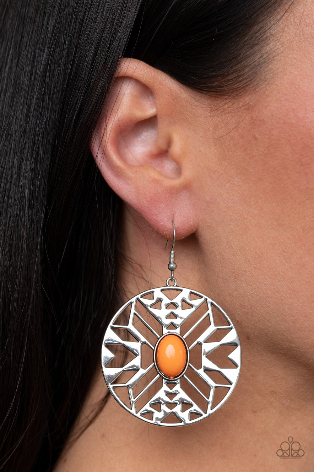 oval Amberglow bead adorns the center of a round silver frame radiating with an airy southwestern inspired pattern