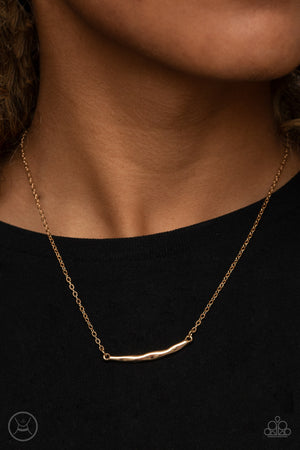 A hammered gold crescent attaches to a dainty gold chain around the neck for a trendy minimalist inspired look