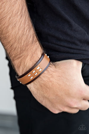 tan leather band is stitched in place across the front of a brown leather band