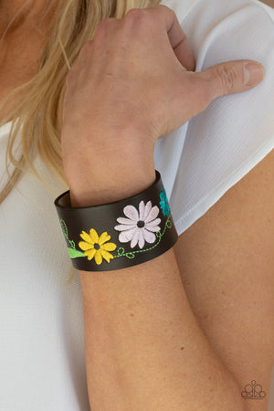 loral pattern is embroidered across the front of a brown leather band