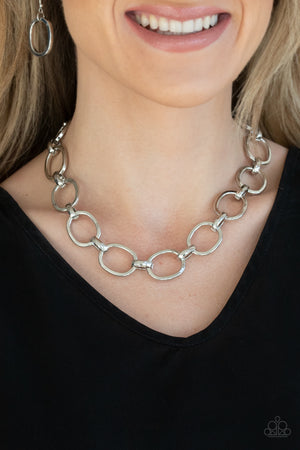 A glistening series of dramatically oversized ovals and links boldly connect below the collar