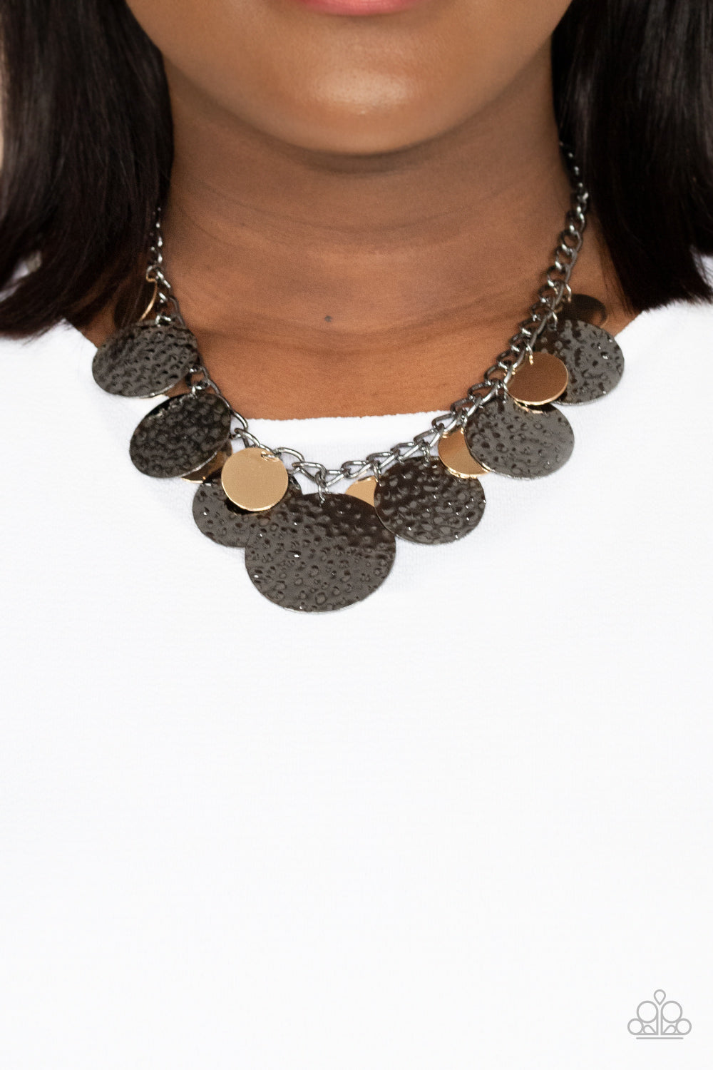 Oversized gold discs and hammered gunmetal discs swing from the bottom of a chunky gunmetal chain