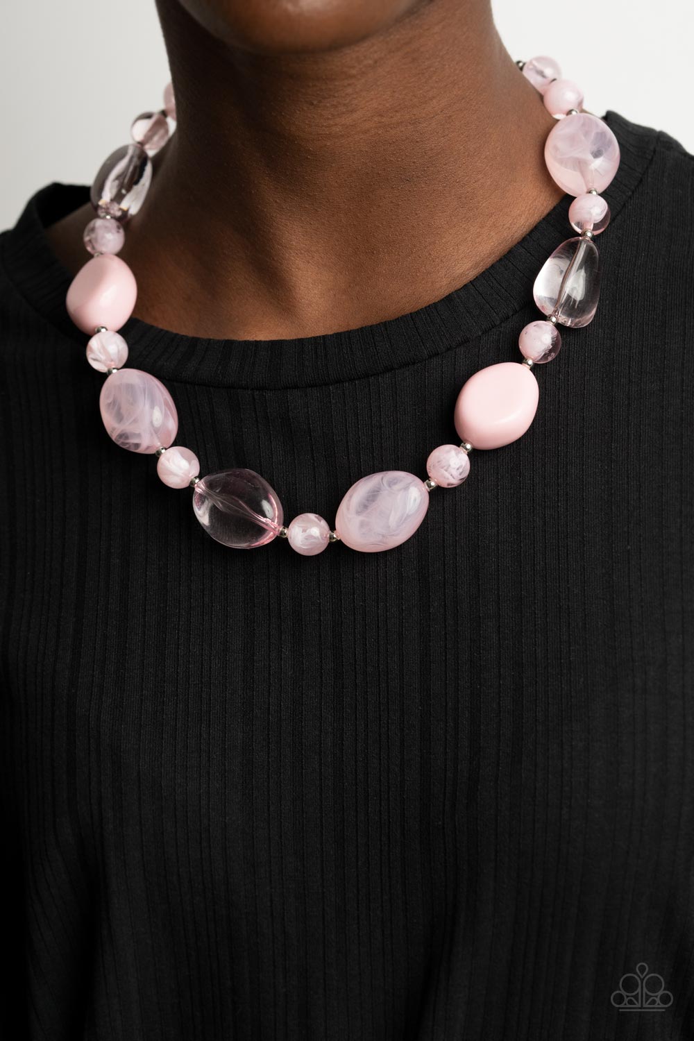 pink faux stone beads and dainty silver beads are threaded along an invisible wire