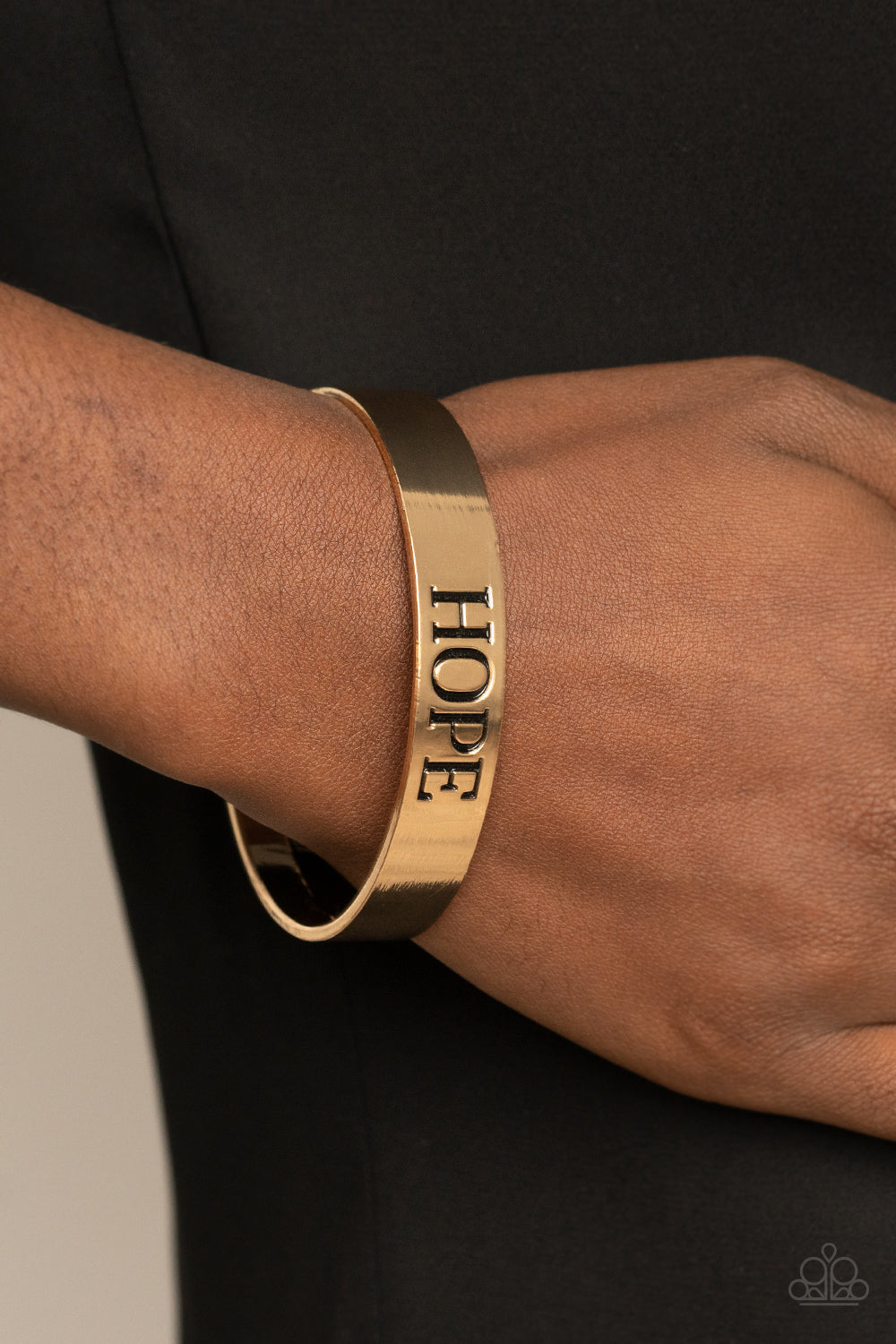 shiny gold cuff is stamped in the word, "Hope," for an inspirational look