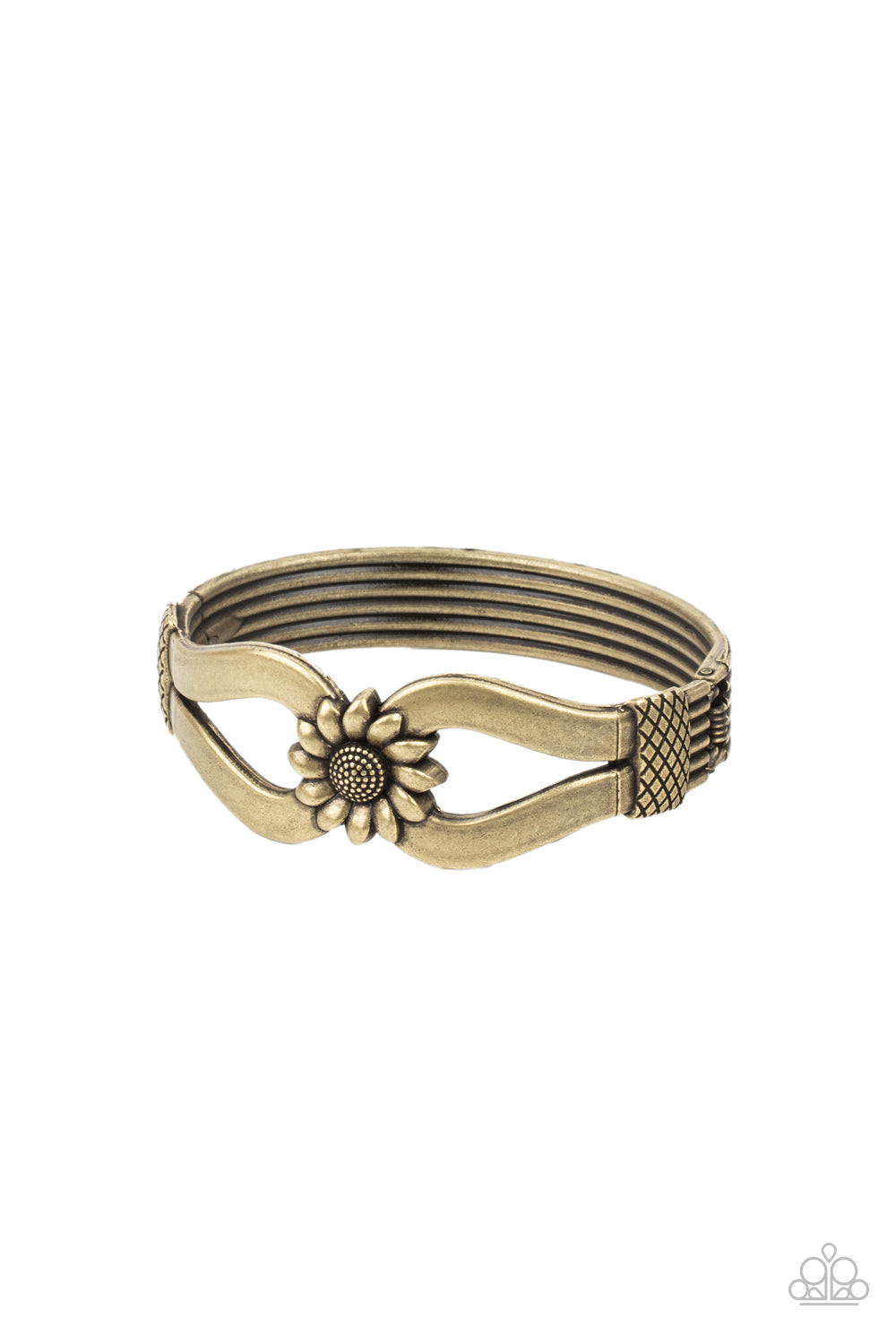 Antiqued brass ribbons loop out from a decorative brass sunflower that attaches to a ribbed brass frame, creating a cuff-like bangle 