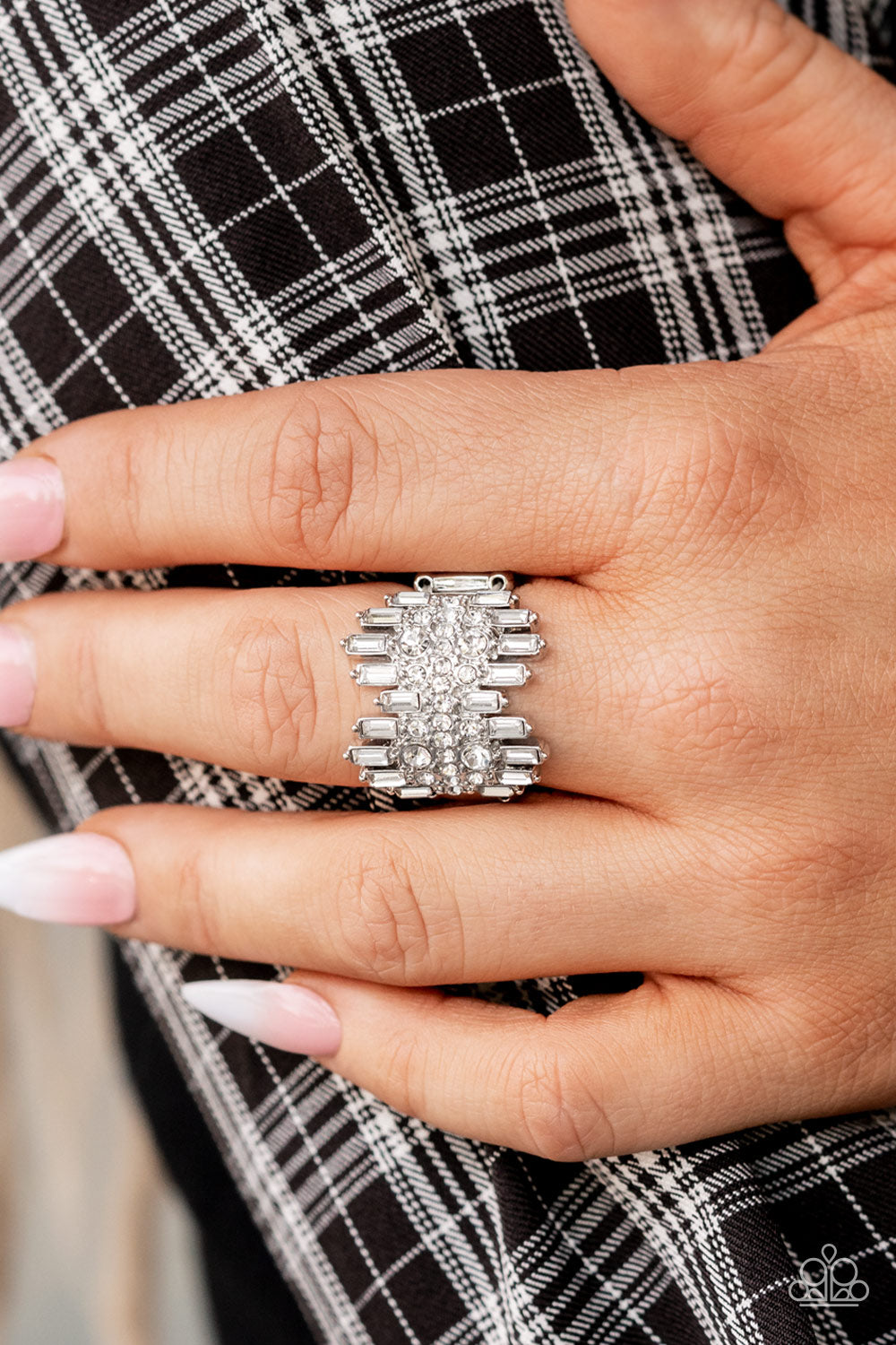 Staggered rows of emerald cut rhinestones flare out from the top and bottom of an explosion of classic white rhinestones