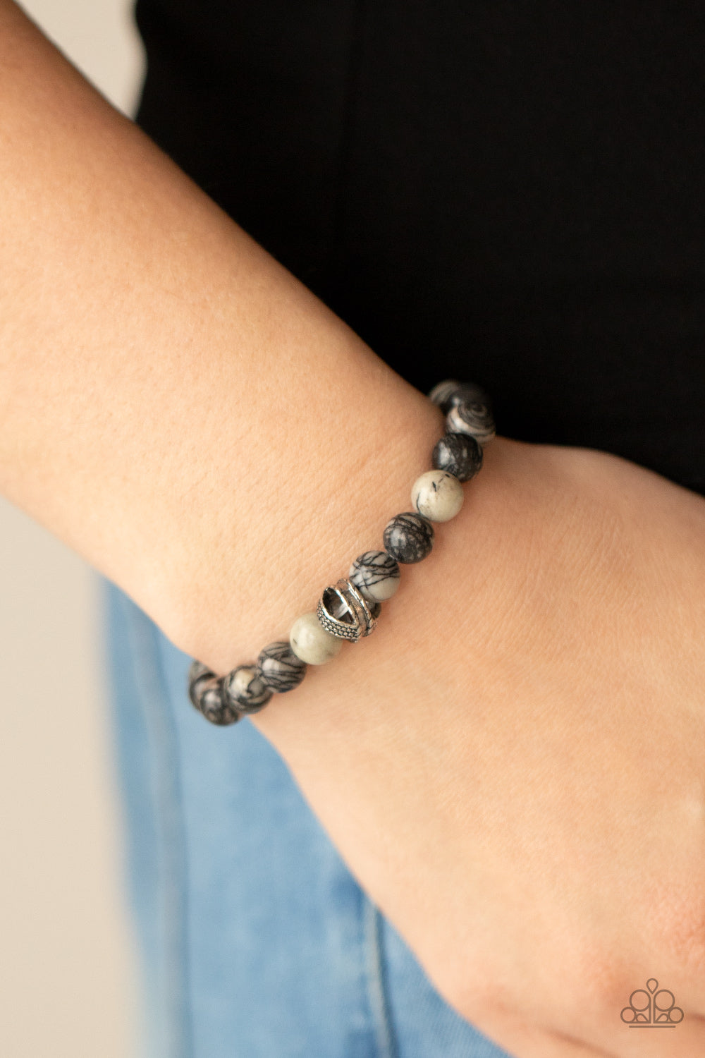 Infused with textured silver accents, an earthy collection of swirling black and white stones