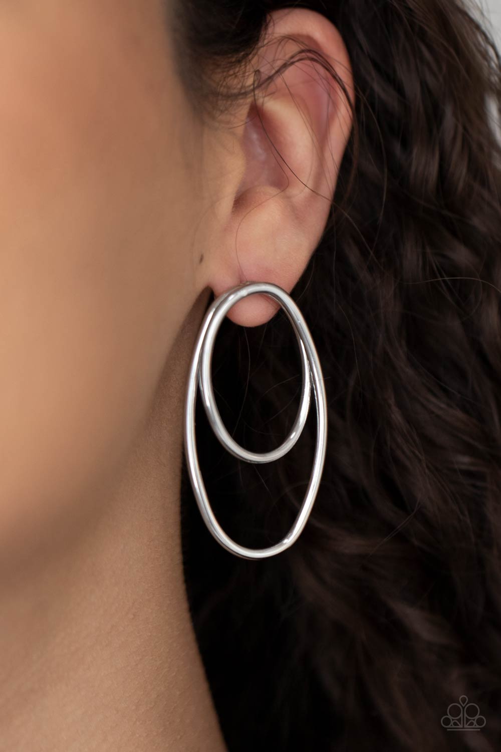 Shiny silver wires spin into a stacked oval frame