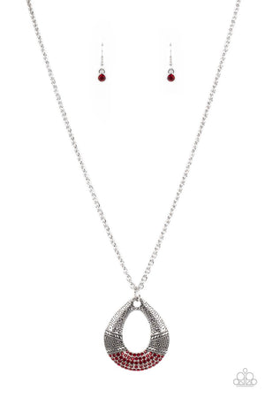 Studded and embossed in bands of texture, the bottom of a hammered silver teardrop is encrusted in fiery red rhinestones