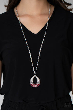 Studded and embossed in bands of texture, the bottom of a hammered silver teardrop is encrusted in fiery red rhinestones