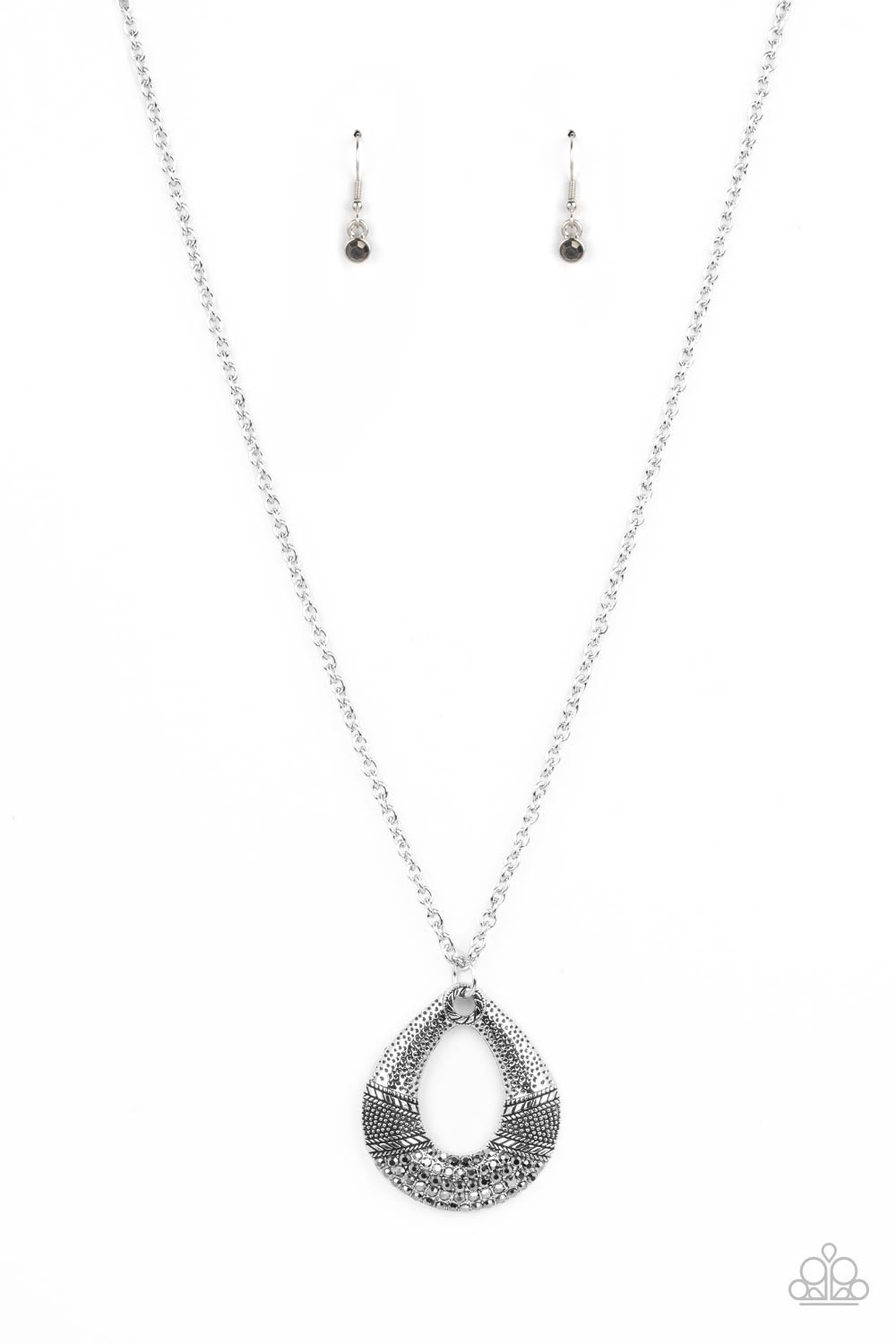 Studded and embossed in bands of texture, the bottom of a hammered silver teardrop is encrusted in smoky hematite rhinestones, creating a glitzy pendant at the bottom of a lengthened silver chain