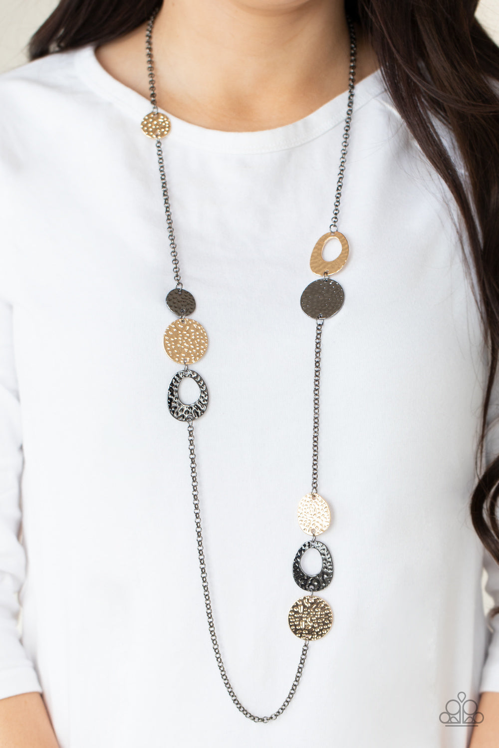 hammered collection of gold and gunmetal discs and asymmetrical rings link with sections of glistening gunmetal chain across the chest