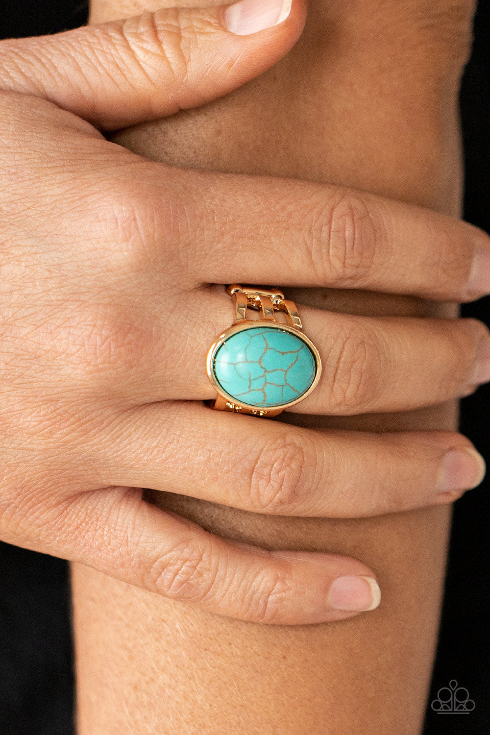 oval turquoise stone is nestled inside a glistening gold frame
