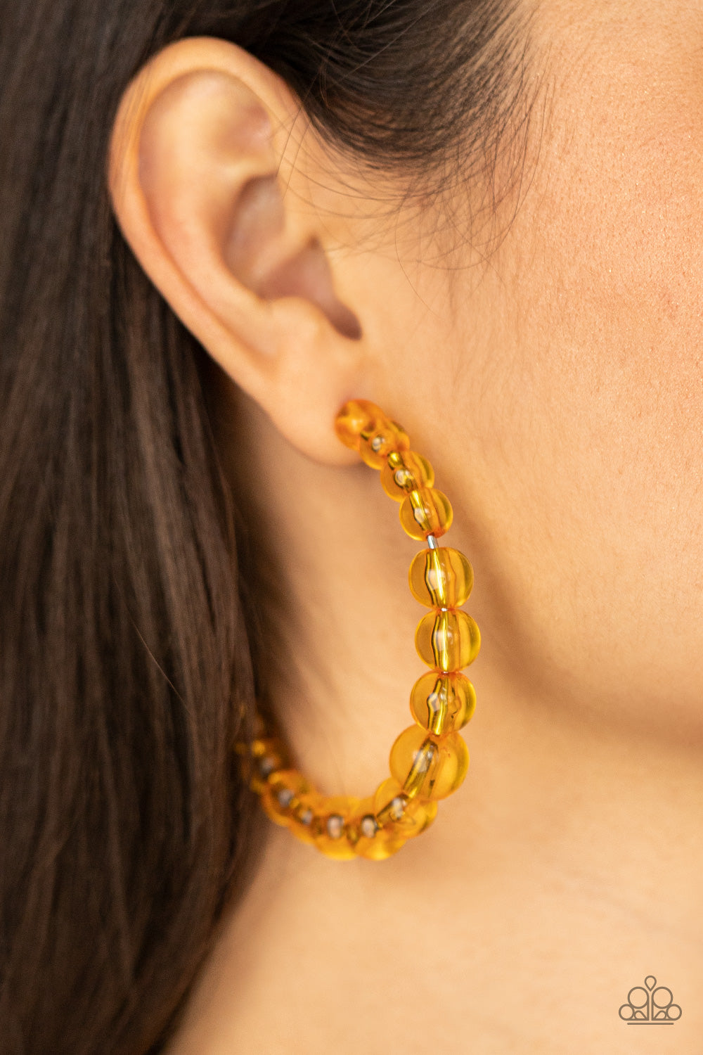 glassy collection of Marigold beads are threaded along an oversized hoop