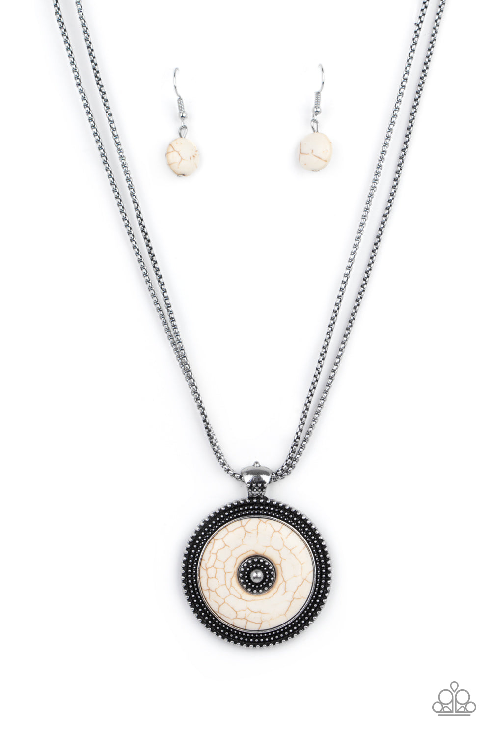  smooth white stone disc is pressed into a textured silver frame radiating with rings of silver studs