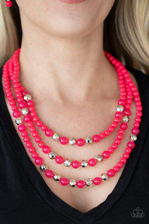 polished pink beads, faceted silver beads, and opaque pink beads are threaded along invisible wires