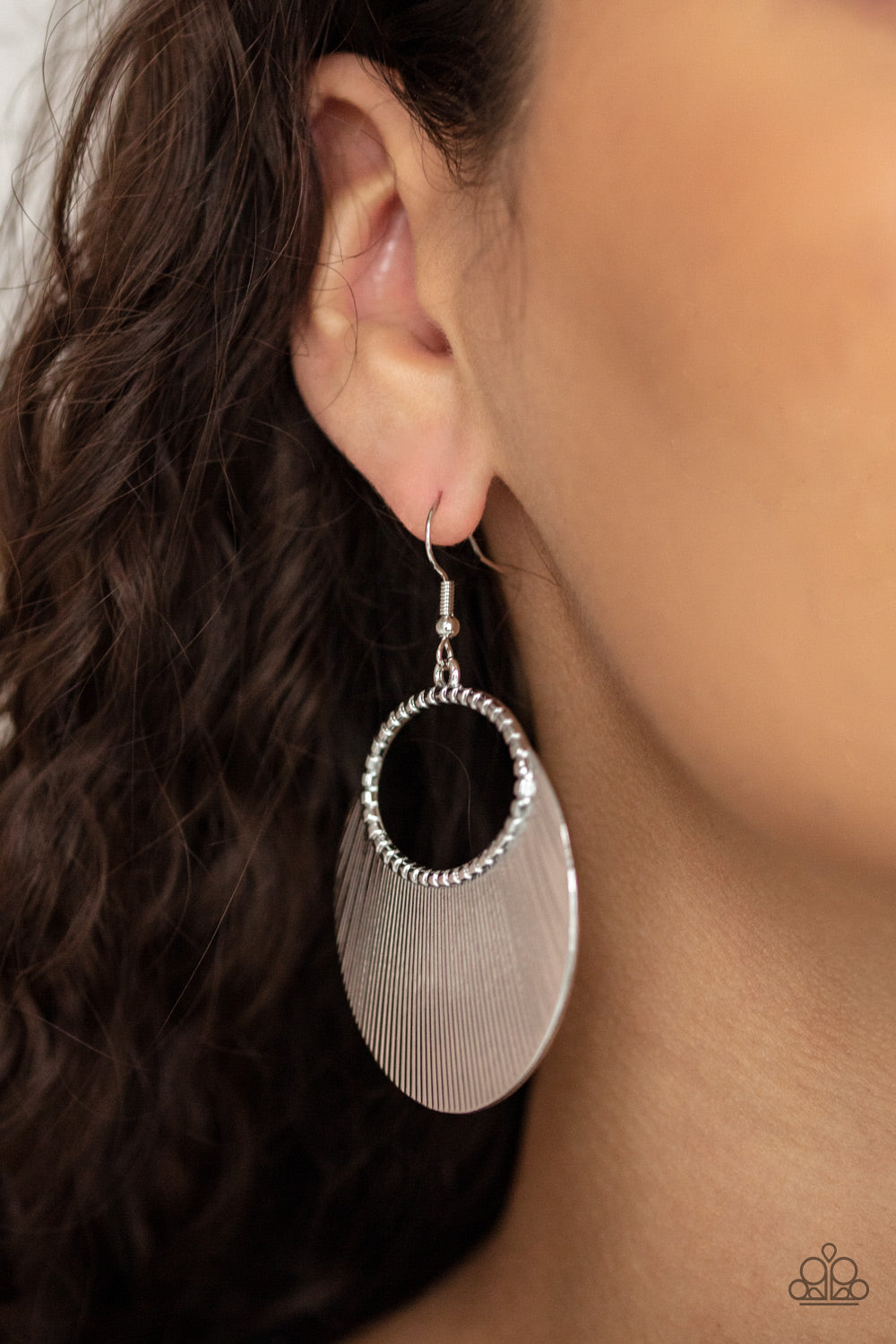 crescent shaped plate fans out from the bottom of a textured silver oval