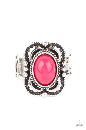 pink bead is encircled inside a metallic ropelike fitting atop a decoratively embossed silver frame