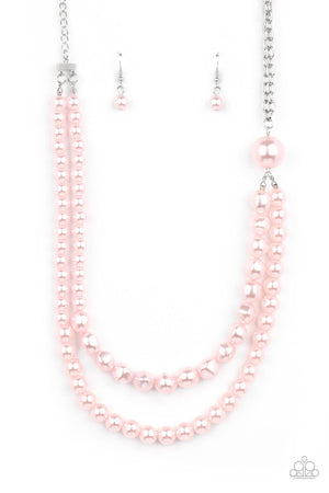 A dramatically oversized pink pearl gives way to two mismatched strands of classic pink pearls