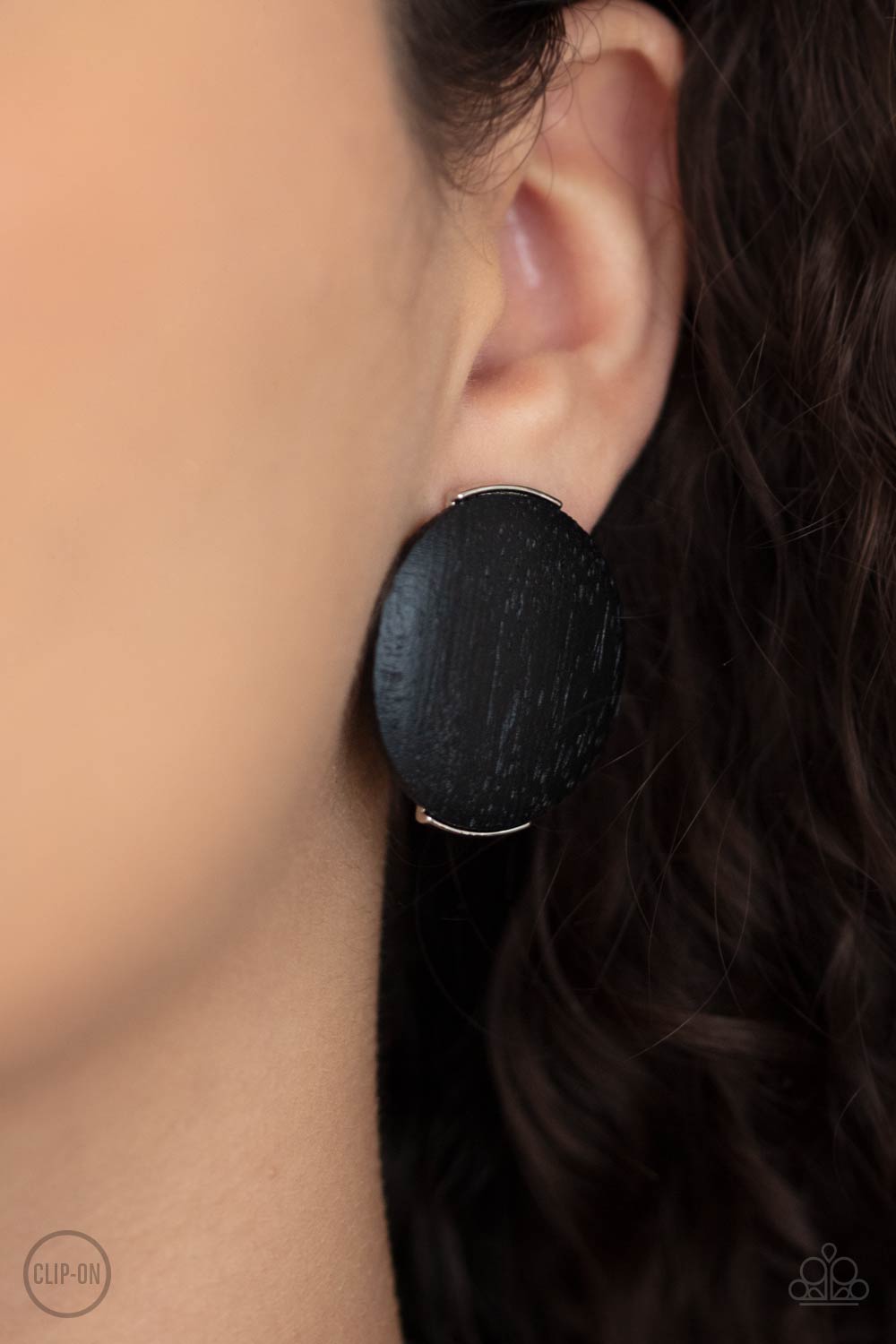 oversized black wooden disc is fitting in place between a silver frame, creating an earthy effect, Clip-On