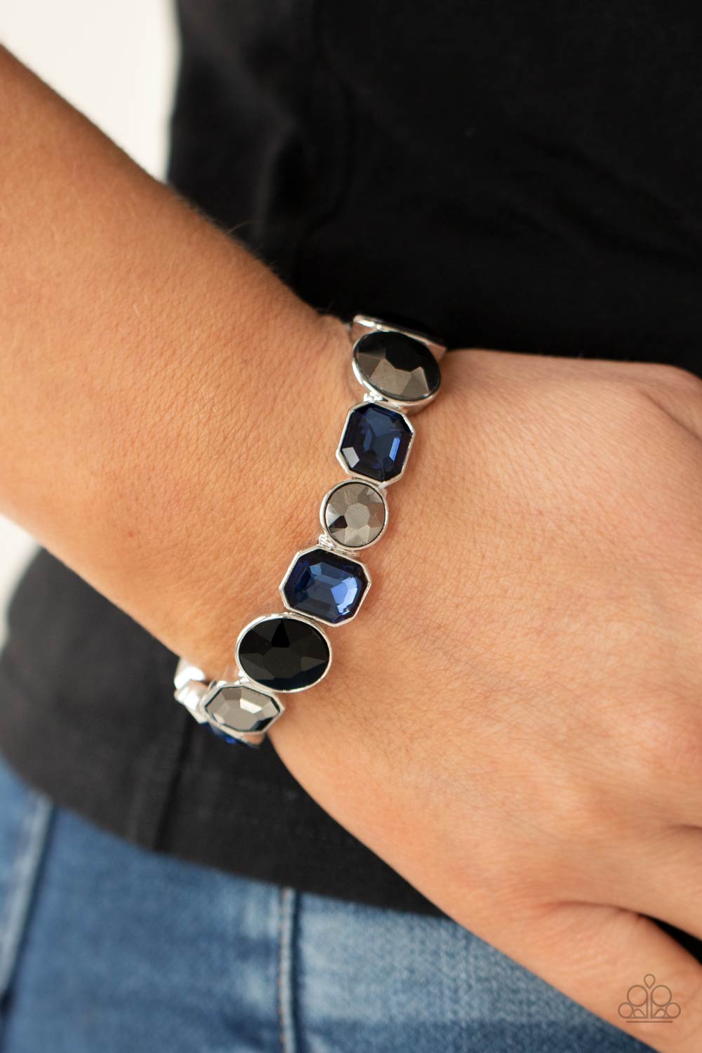 Encased in sleek silver frames, a smoldering collection of round and emerald cut black, blue, and hematite rhinestones