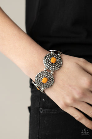 Marigold emerald shaped beads adorn the centers of round silver discs studded and embossed in metallic croc-like textures