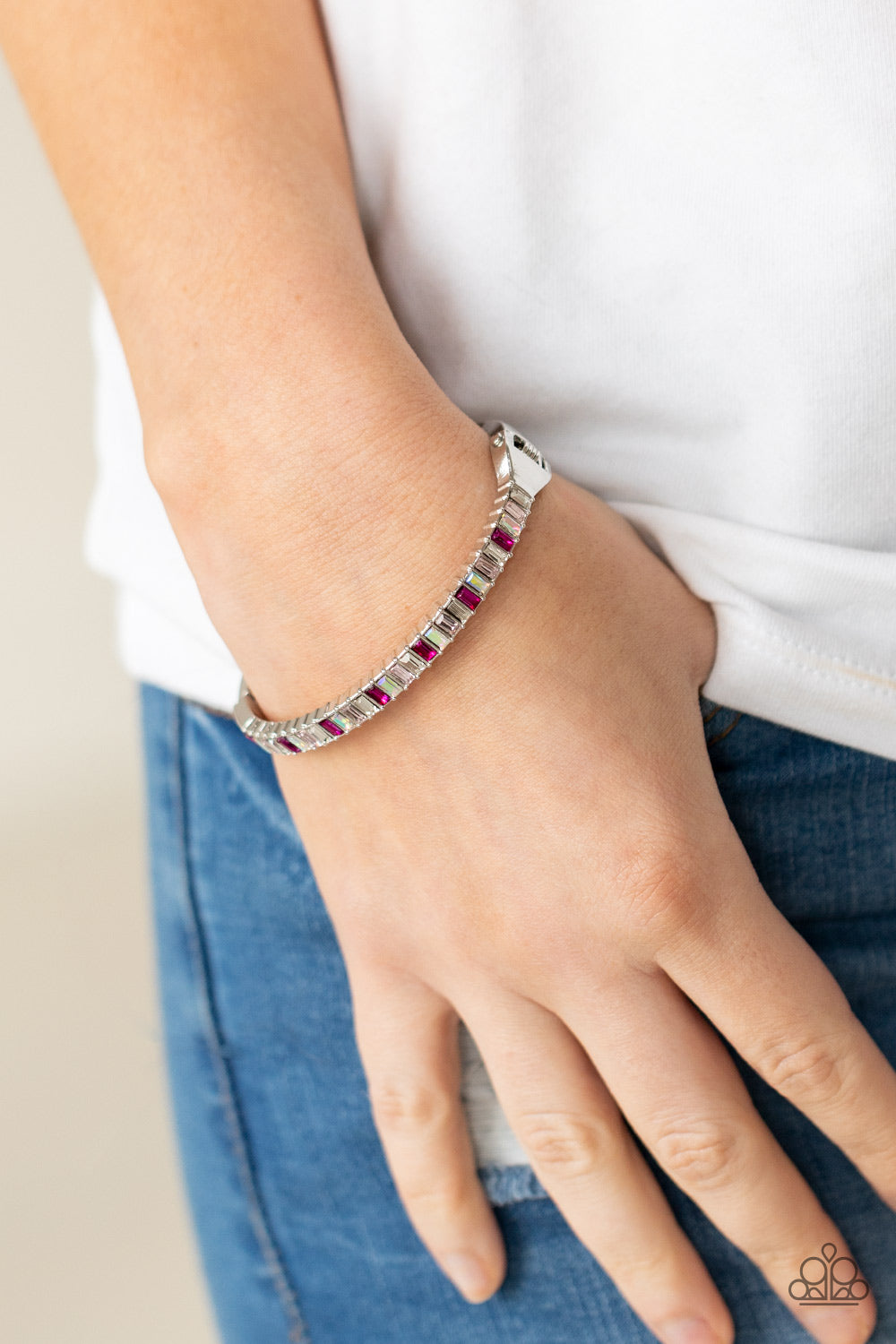 regal emerald style cuts, a dainty row of pink and white rhinestones are encrusted across the front of a silver cuff-like bangle
