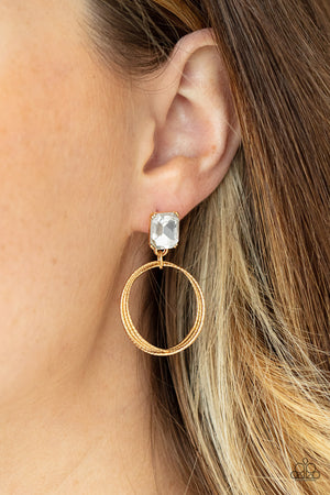 pronged gold setting, a white emerald cut rhinestone links with a trio of refined textured gold rings