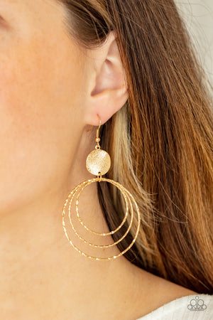 shimmery wavy gold disc links atop a collection of three delicately hammered gold rings in concentric sizes