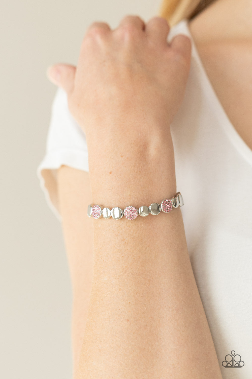 Glittery pink rhinestone encrusted frames and joined pairs of silver discs are threaded along stretchy bands around the wrist
