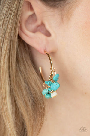 Clusters of turquoise pebbles swing from the bottom of a dainty gold hoop, creating an earthy fringe. A faceted gold and white stone bead swings from the center, adding an ethereal edge