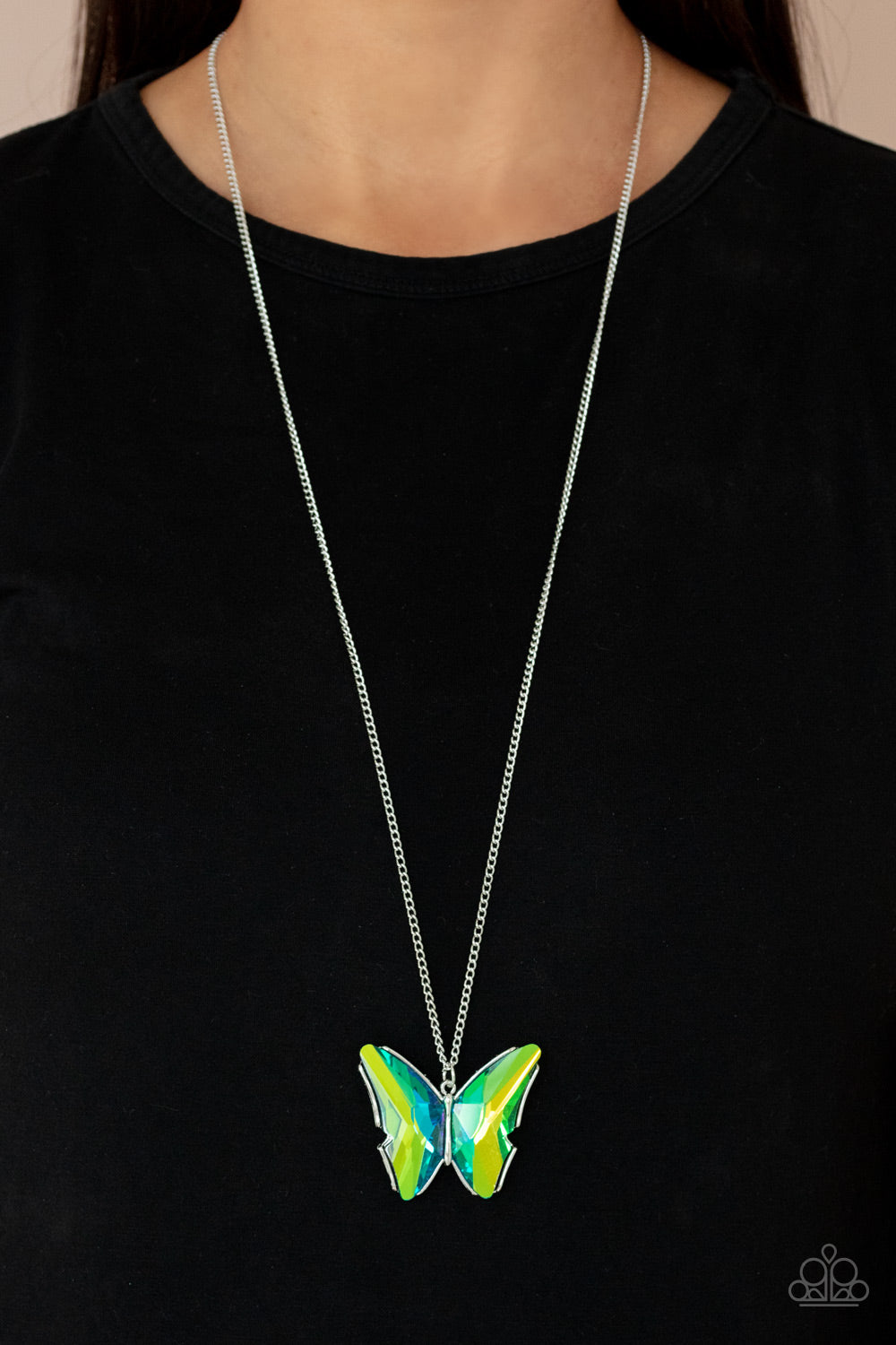 faceted green and blue gems adorn the wings of a silver butterfly