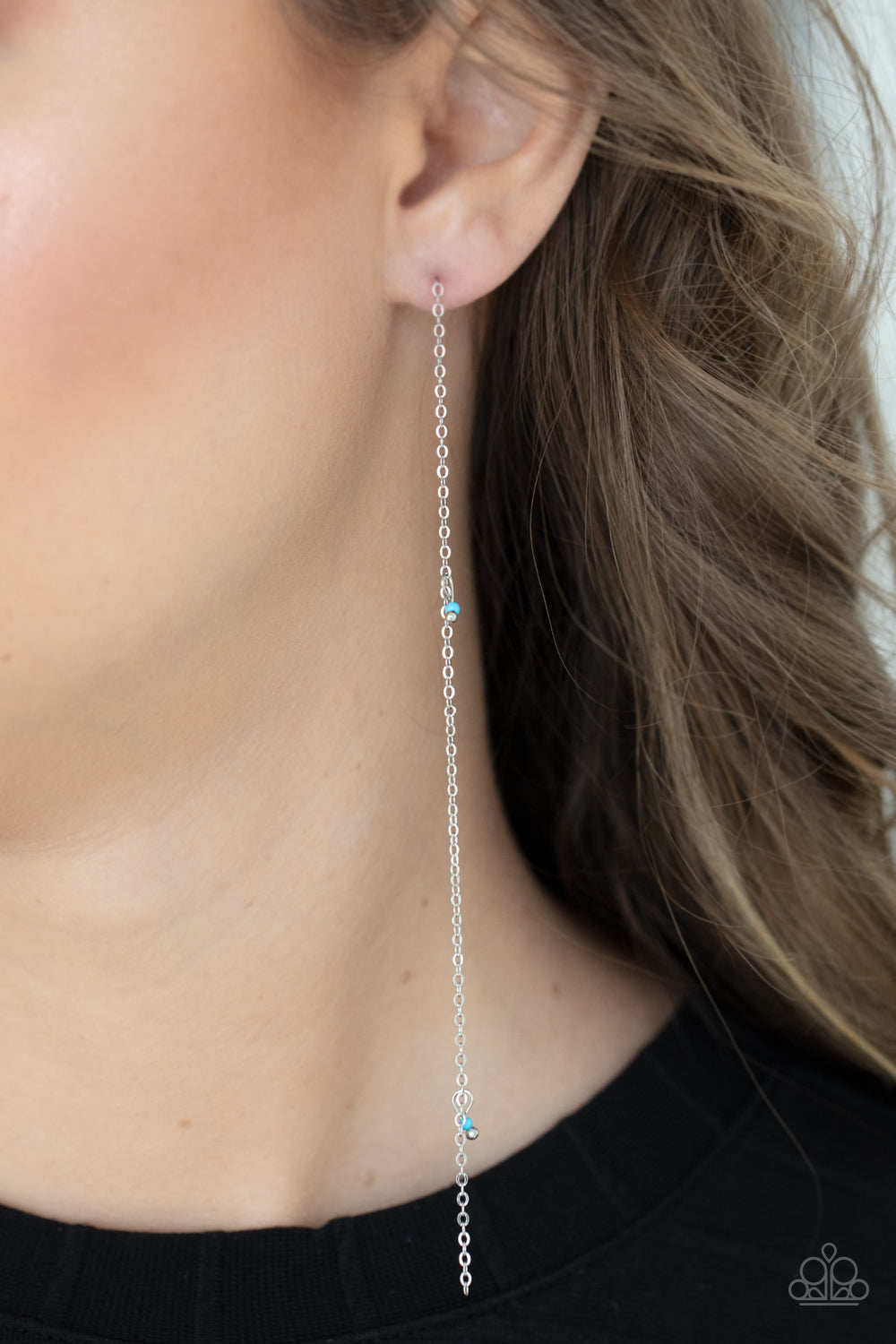 Pairs of dainty silver and Cerulean seed beads trickle along a lengthened silver chain, creating an extended chandelier.