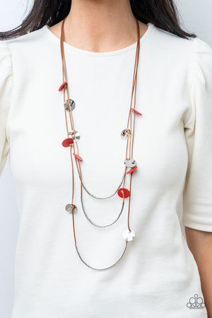 Shining wavy silver discs and red leather discs adorn a trio of lengthened subtly shimmering brown cords. Rows of dainty silver cylinders are threaded along the bottom of each cord adding luxurious allure to the piece.