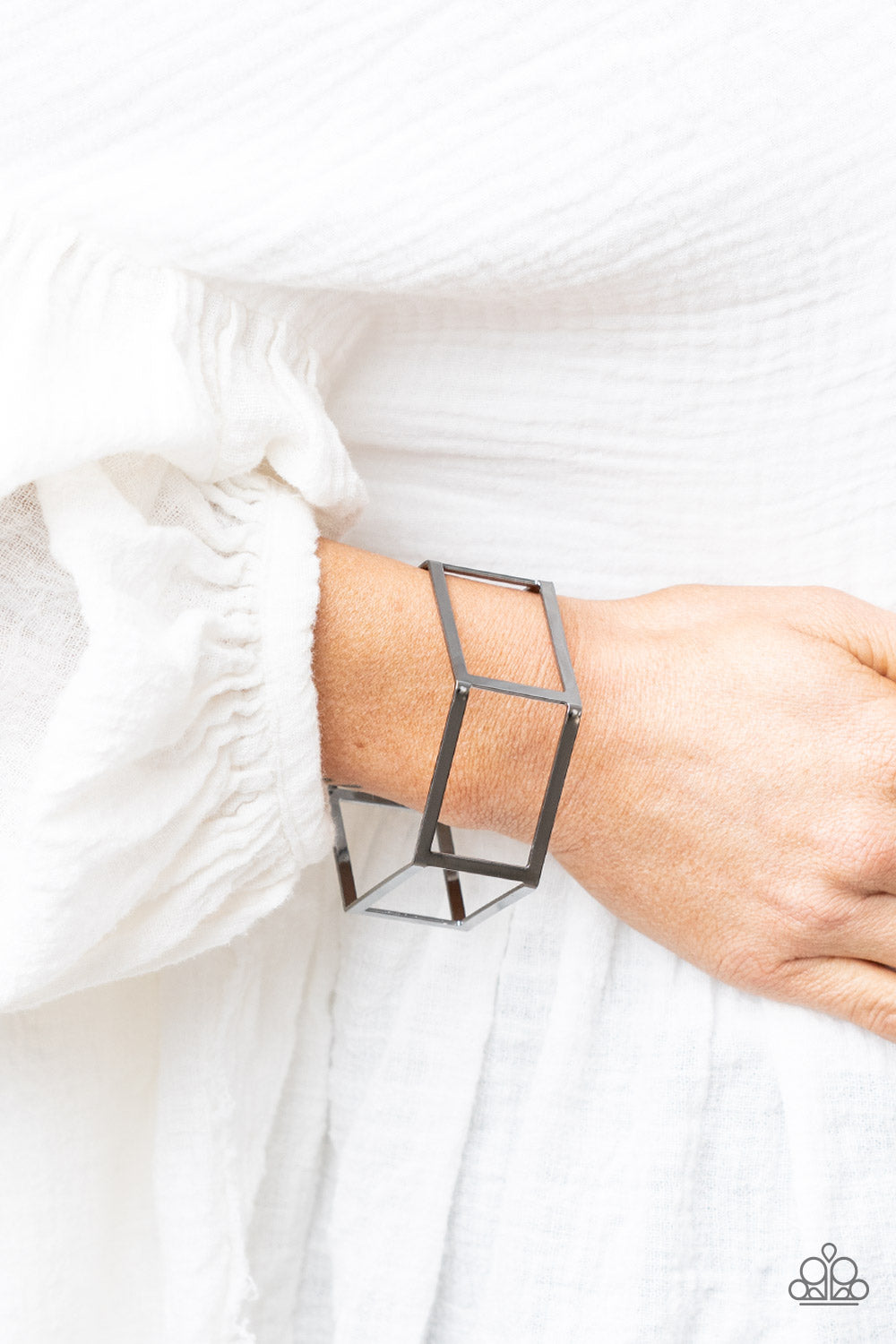 A row of airy gunmetal rectangular frames delicately bend into a hexagonal cuff