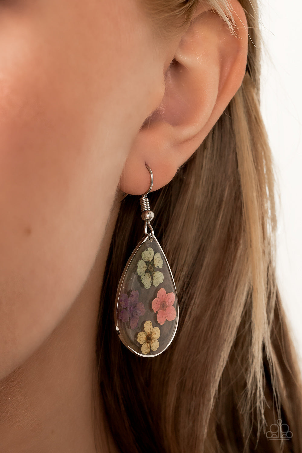 Dainty green, pink, purple, and yellow flowers are encased in a glassy teardrop