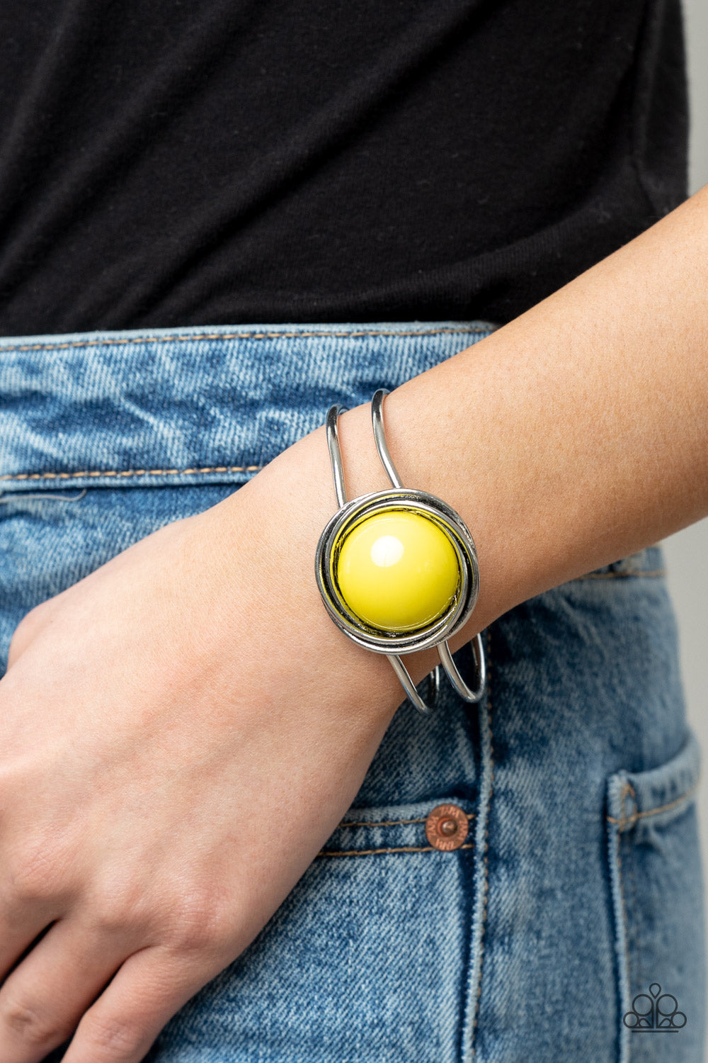 An oversized Illuminating bead is pressed into the center of overlapping silver rings 