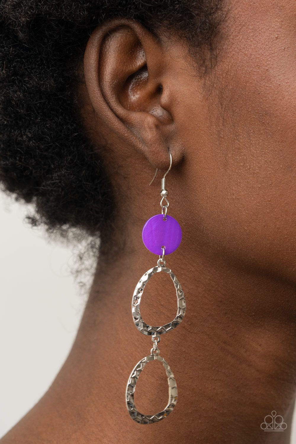 purple shell disc anchors to two shiny hammered silver asymmetrical hoops