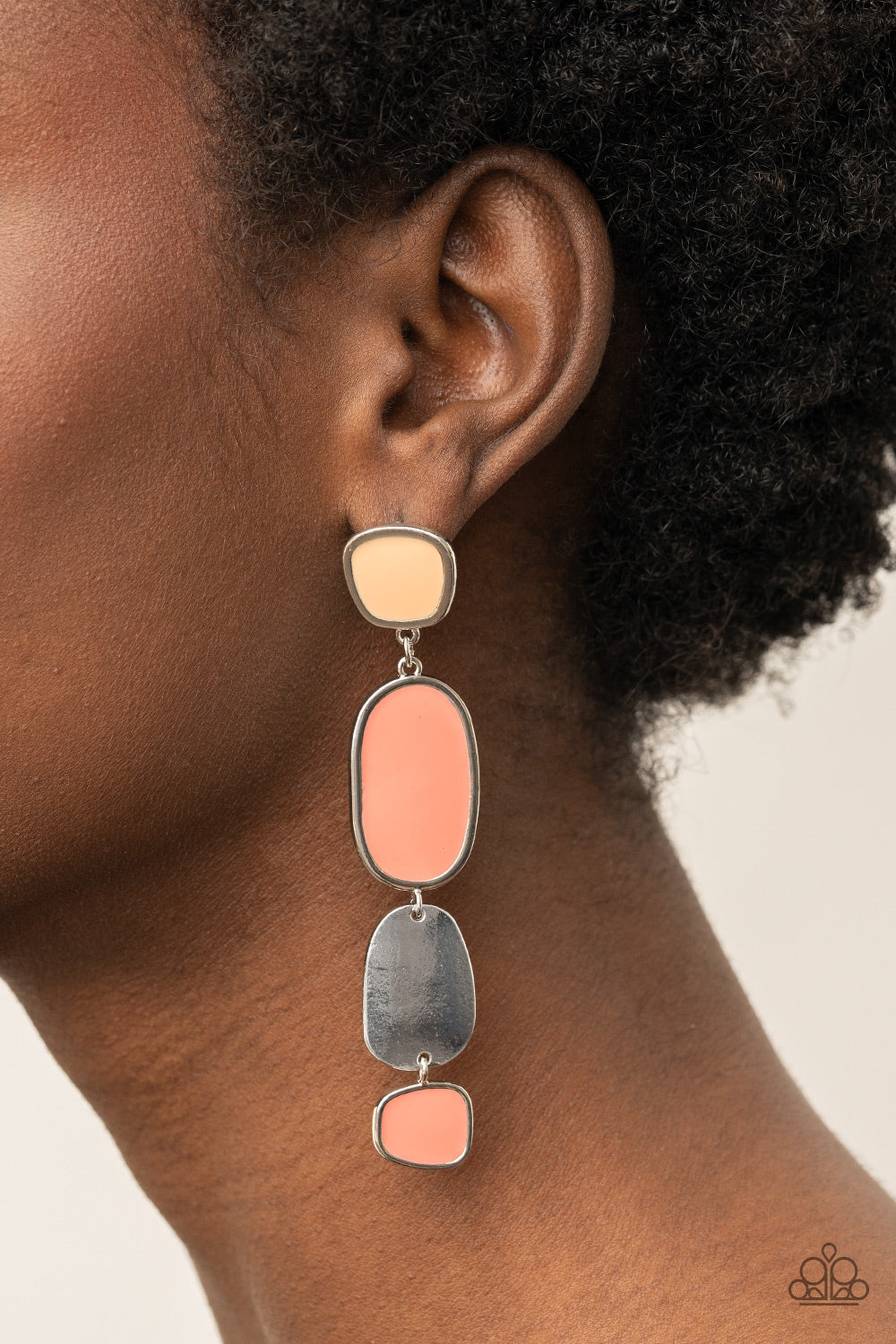 Desert Mist and Burnt Coral finishes, asymmetrical frames attach to a single silver frame