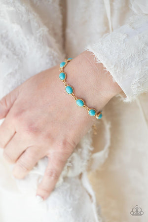 Encased in studded gold frames, oval turquoise stones delicately connect around the wrist 