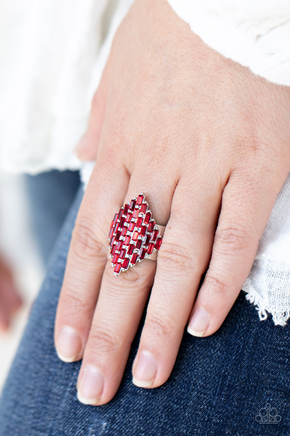 Fiery red emerald cut rhinestones are encrusted across the front of a studded silver frame, creating a sparkly honeycomb shaped centerpiece.