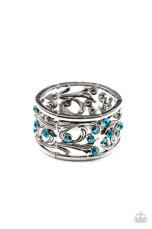 An ombre of blue rhinestones scatters across an airy floral frame among vine-like filigree