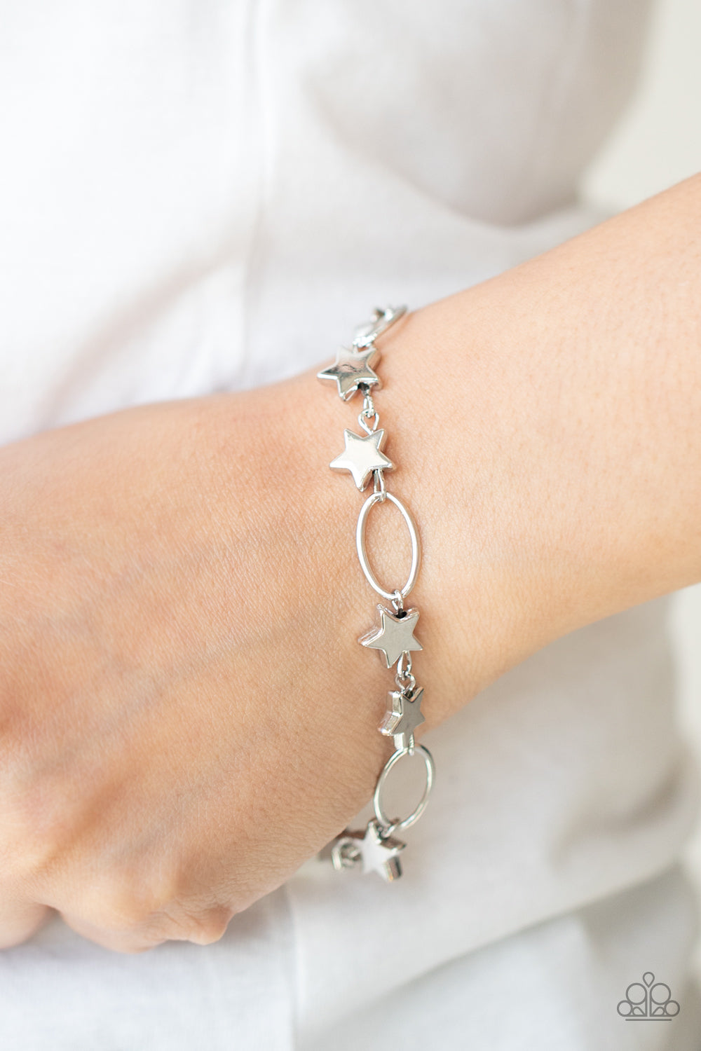 Dainty silver stars and airy silver ovals delicately link around the wrist, creating a stellar 4th of July display. 