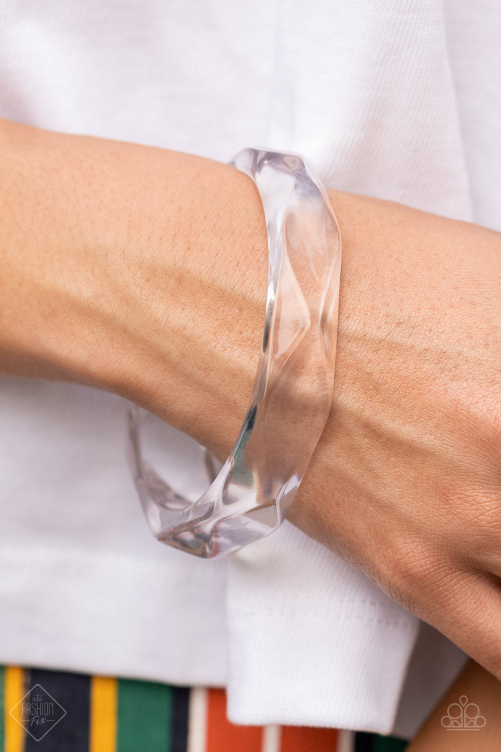 flashy faceted surface, an oversized crystal-like acrylic bangle
