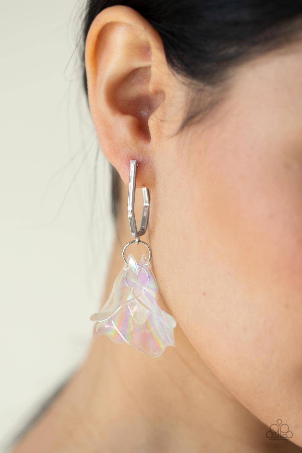 cluster of iridescent acrylic petals swing from the bottom of a dainty silver geometric hoop