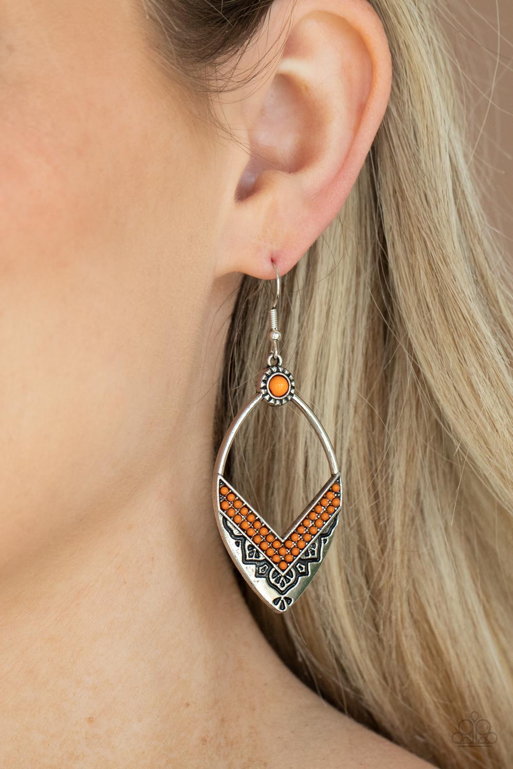 Two rows of orange seed beads create a V at the bottom of an airy silver frame embossed and stamped in indigenous inspired patterns. A matching orange seed bead adorns the top of the frame