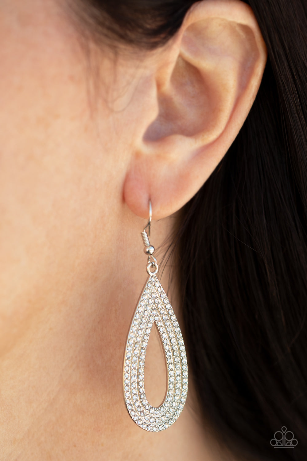 Three glittery rows of glassy white rhinestones coalesce into a sparkly silver teardrop