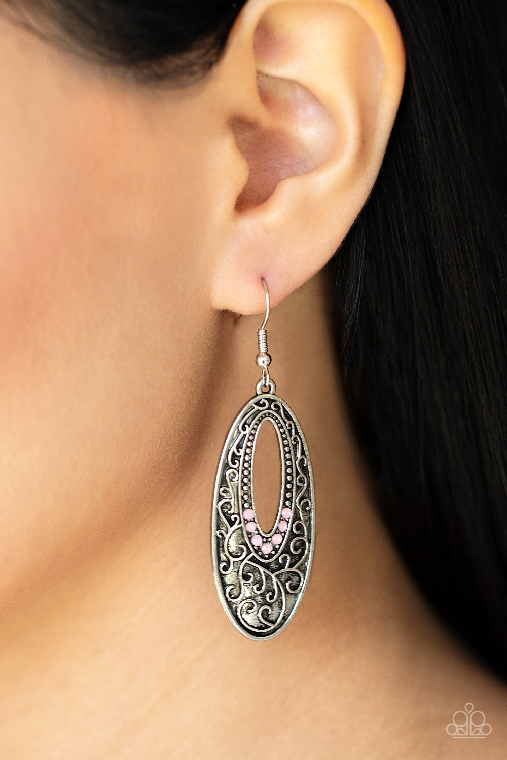 Dainty silver studs fade into dewy pink rhinestones around the airy center of an oval silver frame that is embossed in a vine-like scroll
